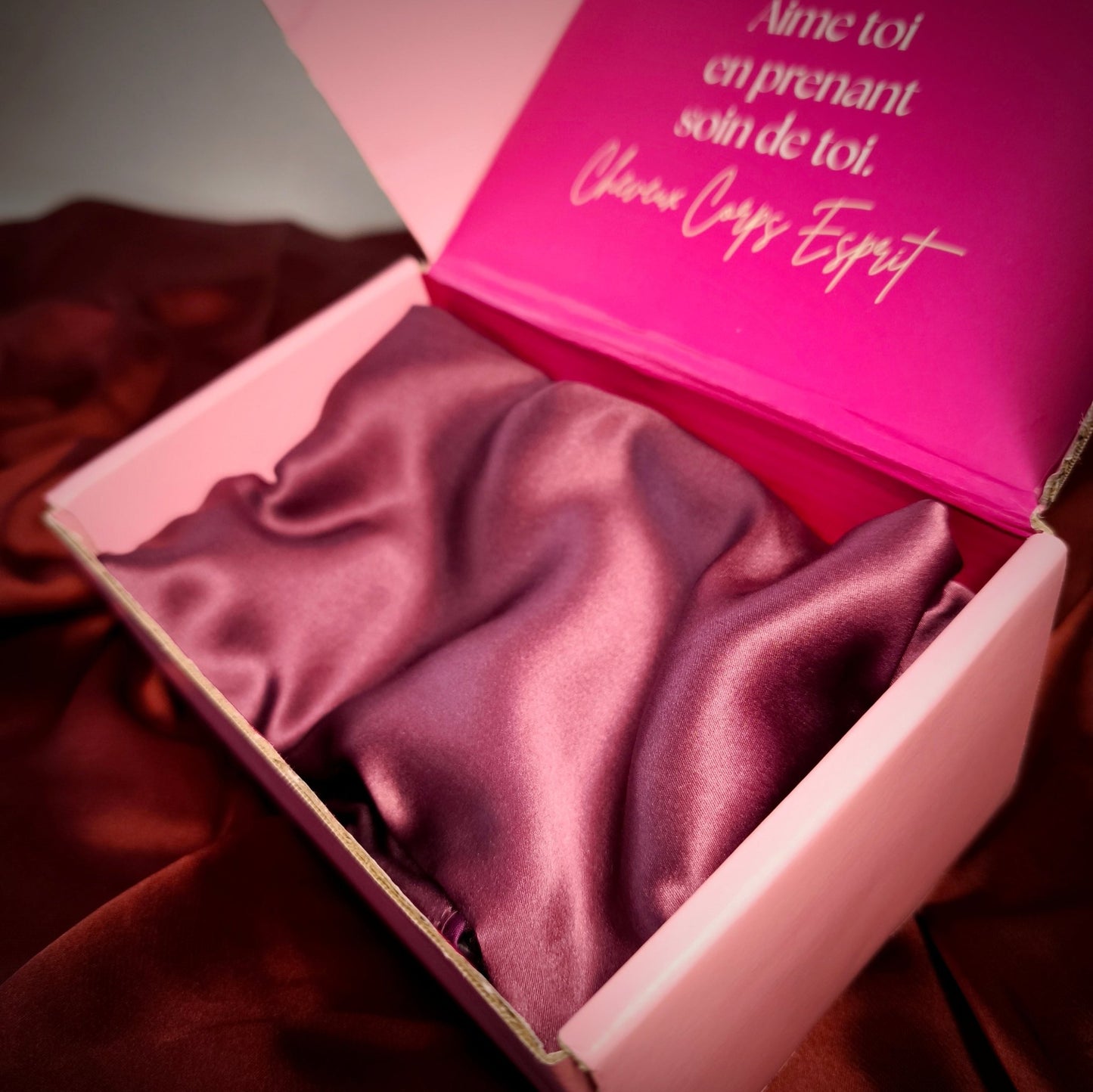 Taie d’oreiller en soie rose dans son coffret de nuit