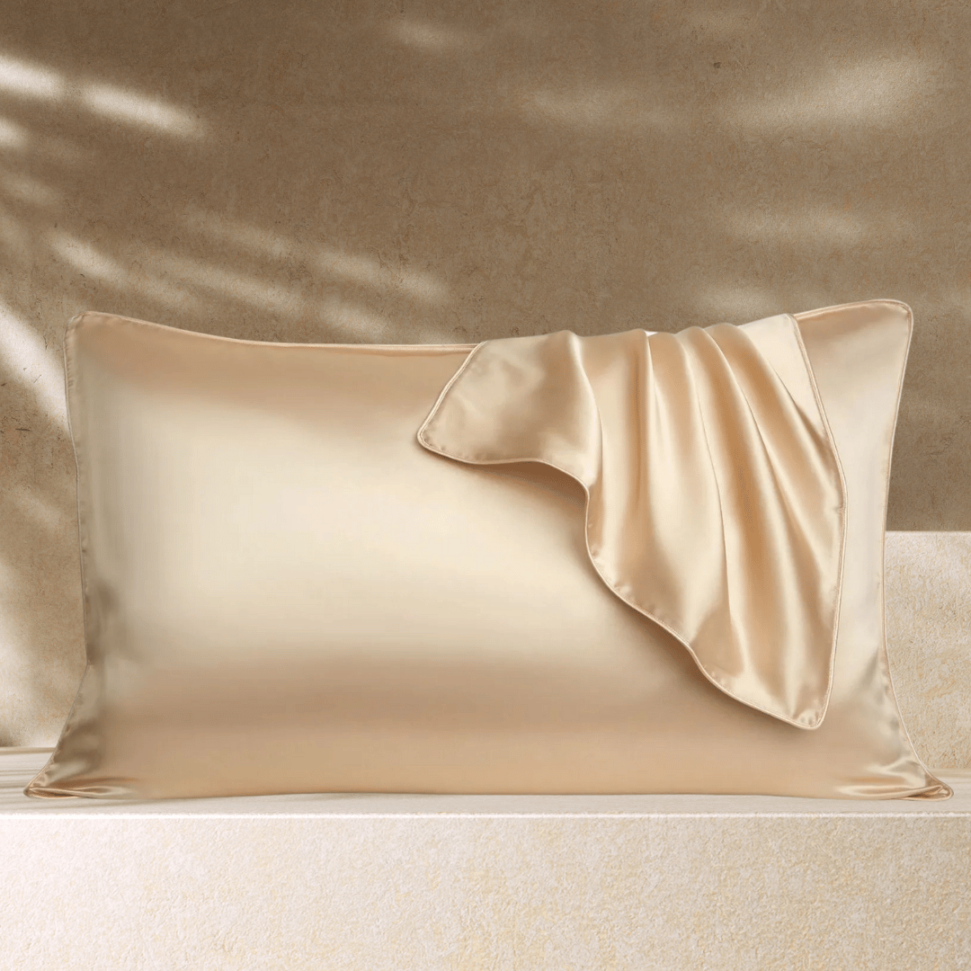 Taie d’oreiller en soie beige posée sur un oreiller