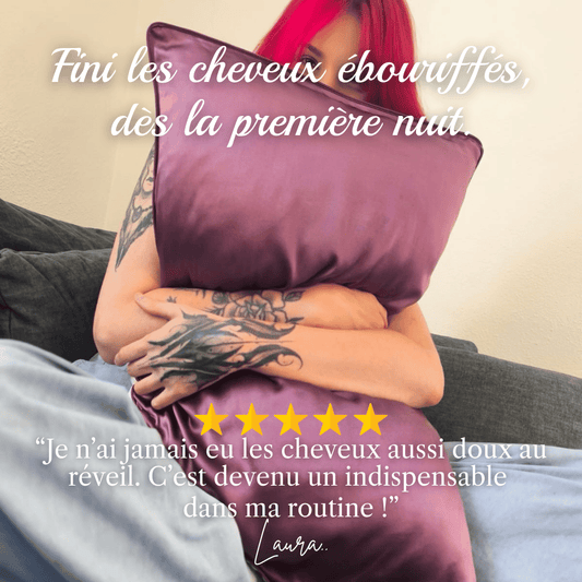 Femme heureuse tenant une taie d'oreiller en soie contre elle, cheveux doux au réveil grâce à la soie