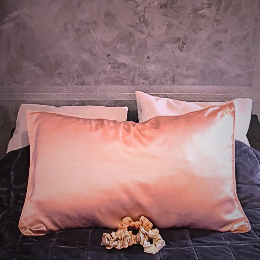 Coffret découverte soie posé sur lit – taie d’oreiller et chouchous en soie en démonstration